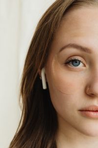Kaboompics - Woman Wearing an Under-Eye Patch and Wireless Earbud in a Beauty Portrait
