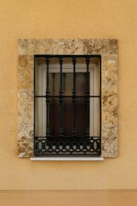 Kaboompics - Barred Window on Warm Yellow Spanish Wall