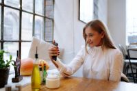 Kaboompics - Blonde Woman Smiling While Holding Smartphone at Cafe