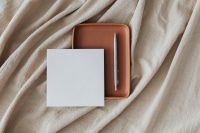 Kaboompics - White Blank Card on Terracotta Leather Tray with Silver Pen and Draped Linen