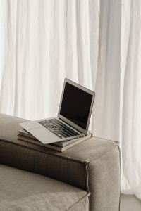 Kaboompics - Open Laptop on Stacked Books by Sheer Curtains, Neutral Home Office Copy Space