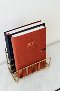 Kaboompics - Red 2020 Planner Set in Brass Rack on White Marble