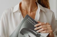 Kaboompics - Woman in a White Shirt Holding an Architecture Photography Book, Minimal Lifestyle Portrait
