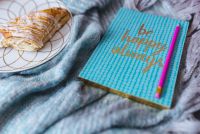 Kaboompics - Blue notebook with a sweet bun on a plate
