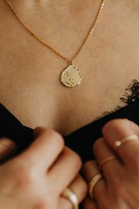 Kaboompics - Woman Holding Pendant Necklace While Adjusting Black Top