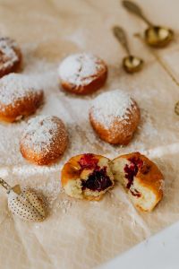 Kaboompics - Traditional Polish Paczki Still Life with Cherry Filling, Powdered Sugar and Gold Sifter