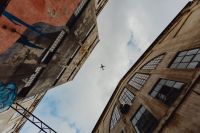 Kaboompics - Airplane Crossing the Sky between Industrial Brick Buildings at LX Factory, Lisbon Portugal