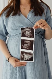 Kaboompics - Pregnant Woman Holding Ultrasound Photos in Blue Dress