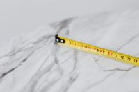 Kaboompics - Tape Measure Hook and Yellow Blade on Soft-Focus White Marble with Copy Space