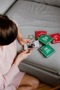 Kaboompics - Woman Using Smartphone beside Christmas Gift Boxes