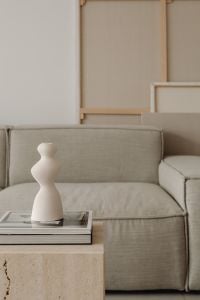 Kaboompics - Sculptural Ceramic Vase on a Travertine Side Table Beside Greige Sofa