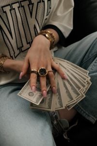 Kaboompics - Close Up of Hands With Cash Rich Life Aesthetic