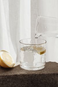 Kaboompics - Fresh Lemon Half and Glassware in a Water Pouring Setup
