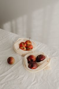 Kaboompics - Fresh Apples in Reusable Mesh Produce Bags on White Linen, Zero-Waste Grocery Still Life