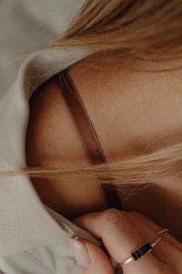 Kaboompics - Woman Adjusting Tan Silk Shirt with Gold Jewelry