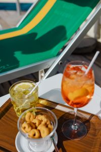 Kaboompics - Aperol Spritz and Bowl of Taralli on Striped Chair Fabric