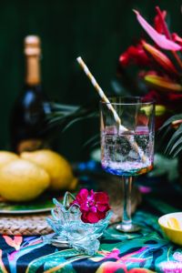 Kaboompics - Refreshing Summer Drink with Striped Straw, Lemons and Tropical Flowers on a Garden Party Table