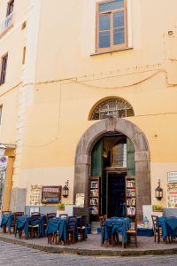 Kaboompics - Sorrento Restaurant Entrance With Books, Outdoor Tables And Yellow Facade