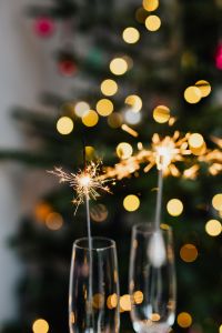 Kaboompics - New Year's Eve Sparklers in Champagne Glasses Against Christmas Tree Lights