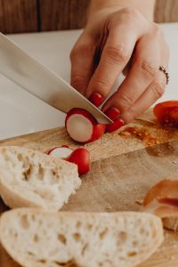 Kaboompics - Slicing Radishes Beside Rustic Bread and Tomatoes