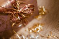 Kaboompics - Gold Mesh Gift Bow and Wrapped Present with Soft Party Bokeh