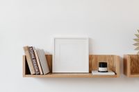 Kaboompics - Empty White Frame Mockup Styled on Wooden Shelf with Books and Candle