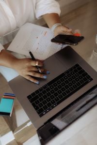 Kaboompics - Hands Editing a Document Beside Laptop