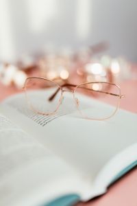 Kaboompics - Rose Gold Reading Glasses on a Book with Pink Negative Space