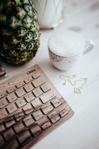 Kaboompics - Pineapple beside Coffee Cup and Wooden Keyboard in a Vertical Frame