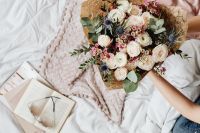 Kaboompics - Large Flower Bouquet on Bed Beside an Open Book and Pink Throw