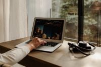 Kaboompics - Laptop Showing City Photos Beside Camera at Window Desk
