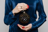 Kaboompics - Woman in Blue Sweater Holding a Dark Glass Christmas Bauble, Holiday Decor Close-Up