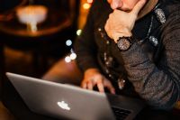 Kaboompics - Man Typing on Laptop beside Wrapped Holiday Gifts