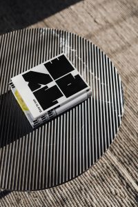 Kaboompics - Overhead Design Book Flat Lay on a Striped Round Coffee Table