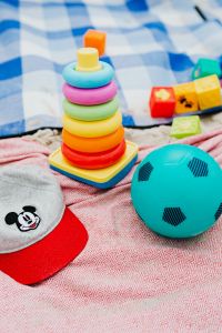 Kaboompics - Rainbow Stacking Rings, Toy Blocks and Ball on a Blue Check Beach Blanket