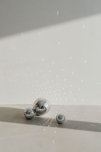 Kaboompics - Three Disco Balls Beneath Reflected Light on a Pale Wall