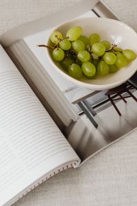 Kaboompics - Close-Up Green Grapes and Open Magazine on a Linen Sofa