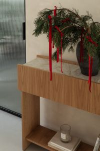 Kaboompics - Evergreen Arrangement with Red Ribbons beside Ribbed Glass Door