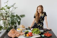 Kaboompics - Young Woman Arranging Fresh Salad Ingredients on Kitchen Counter