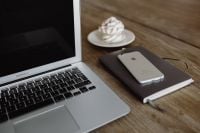 Kaboompics - Silver Apple MacBook Pro with a meringue, smartphone and a notebook on a table