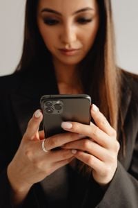 Kaboompics - Close-Up of a Woman Using a Smartphone in a Black Suit