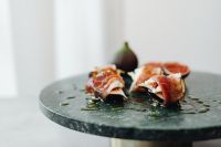 Kaboompics - Prosciutto-Wrapped Figs On Dark Stone Serving Board