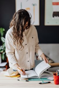 Home Office Productivity and Study - Woman Working with Books, Laptop and Notebook