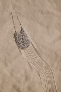 Kaboompics - Silver Beaded Bag with Long Strap on the Sand