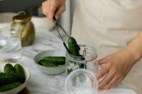 Kaboompics - Hands Placing Cucumbers into a Glass Jar with Tongs