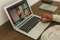 Kaboompics - Woman Browsing Photo Gallery on Laptop at Wooden Desk