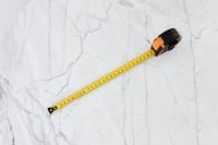 Kaboompics - Top-Down View of a Full Tape Measure Laid across a White Marble Surface