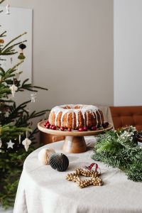 Kaboompics - Iced Bundt Cake on Christmas Table with Tree and Greenery