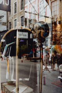 Kaboompics - Reflective LX Factory Boutique Window with Hanging Clothes and Street Scene, Lisbon Portugal