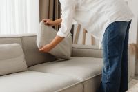Kaboompics - Woman Arranging a Sofa Cushion in a Living Room
